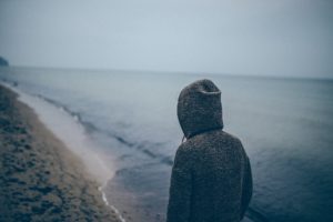 Woman walking on a beach under overcast skies