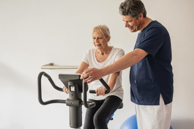 Older woman on bike with kinesiologist